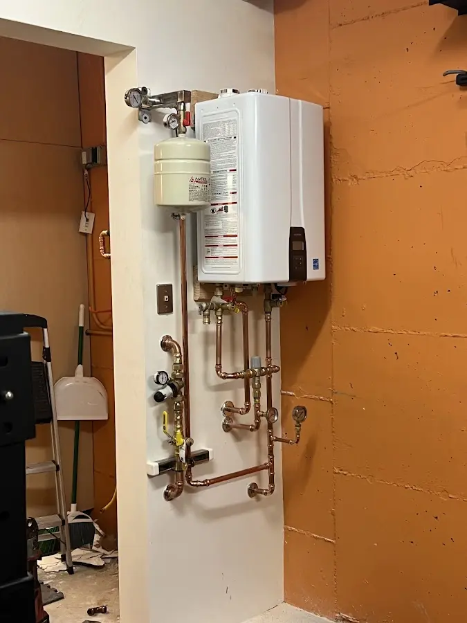 Plumbing technician inspecting water heater connections in Wood Village